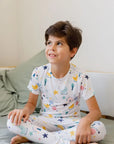 A child wearing our Amara Short Sleeve Pyjama, cozy in soft bamboo fabric with dreamy moon and star prints inspired by “Amara ya Amara.”