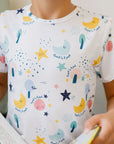Close-up of our Amara Short Sleeve Pyjama featuring soft pastel moons, stars, and Arabic script from the lullaby “Amara ya Amara.”