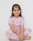 A girl wearing our Amira Short Sleeve Pyjama, feeling like a little princess in soft bamboo comfort and floral castle prints.