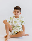 A relaxed boy sitting comfortably while wearing our Ashta Loungewear set, blending cozy comfort with playful annona-inspired style.