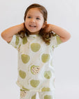A joyful girl smiling brightly while wearing our Ashta Loungewear set, featuring the fun and fruity annona-inspired print.