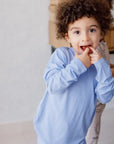 A playful child smiling shyly in our Bahry Long Sleeve Kids Pyjama, made from soft, breathable bamboo fabric for all-day coziness.