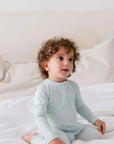 A baby wearing our Reef Pyjama, cozy in its timeless solid tone and buttery-soft bamboo fabric.