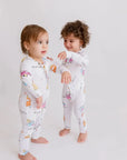Two little ones wearing our Bosta Pyjamas, matching in playful Lebanese bus-inspired prints that celebrate culture and comfort.