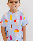 A cheerful boy smiling brightly while wearing our Boza Loungewear set, featuring colorful ice cream prints for a fun summer look.