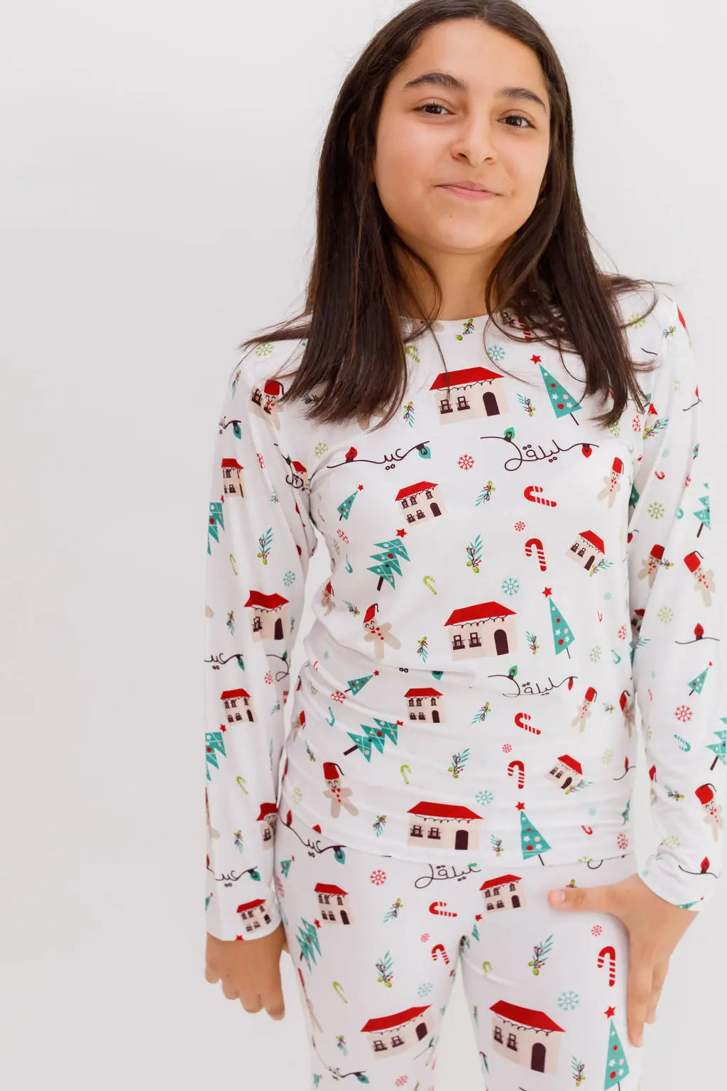 A smiling girl wearing our Christmas Long Sleeve Kids Pyjama, featuring Levant-inspired festive patterns that capture the warmth of the holiday season.