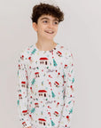 A happy boy standing and smiling in our Christmas Long Sleeve Kids Pyjama, featuring charming Levant-inspired holiday patterns.