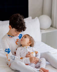 An older brother lovingly holding his baby sibling, both dressed in our matching Huroof Long Sleeve Kids Pyjamas, blending warmth, comfort, and cultural charm.