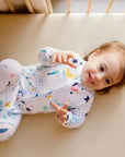 A baby lying happily on our Nohm Ramly Crib Sheet, enjoying the soft and breathable comfort of its bamboo fabric.