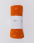 An ultra-soft orange Nohm baby blanket neatly rolled and ready to wrap your little one in comfort.