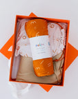 A cozy newborn bedding gift set beautifully arranged in an orange box, featuring our **Nohm Luxury Bedding Gift Set** made from ultra-soft, breathable bamboo fabric.