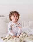 A baby sitting happily on our Nohm Ramly Bedding Set, enjoying the softness and calm of its minimalist bamboo design.