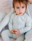A baby wearing our Reef Pyjama, cozy and calm in its soft, timeless bamboo design made for gentle snuggles.