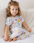 A little girl wearing our Amara Short Sleeve Pyjama, wrapped in soft bamboo comfort and dreamy moon-and-star prints.