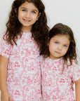 Two girls wearing our Amira Short Sleeve Pyjama, twinning in soft bamboo comfort and dreamy princess-inspired prints.