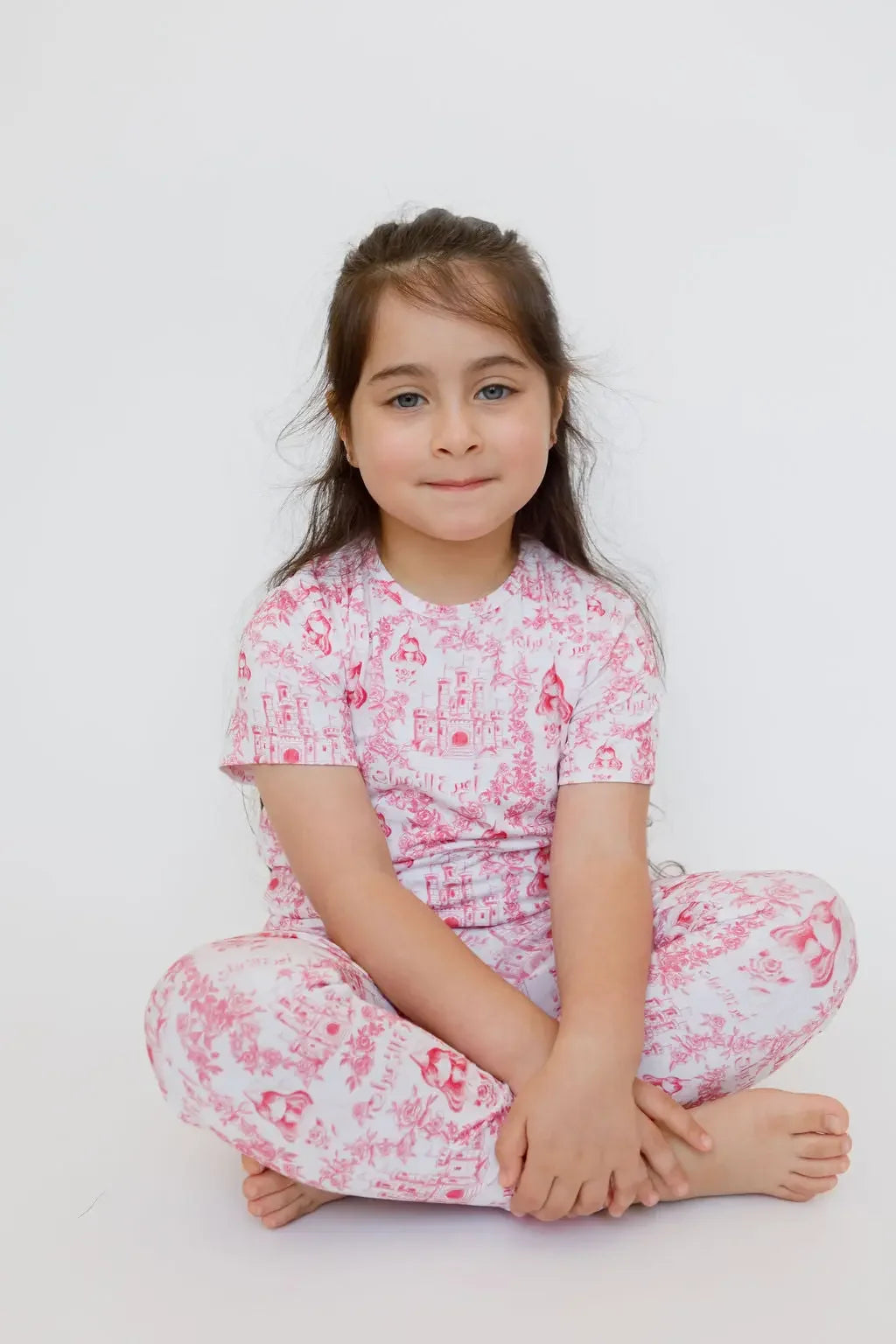 A girl wearing our Amira Short Sleeve Pyjama, feeling like a little princess in soft bamboo comfort and floral castle prints.