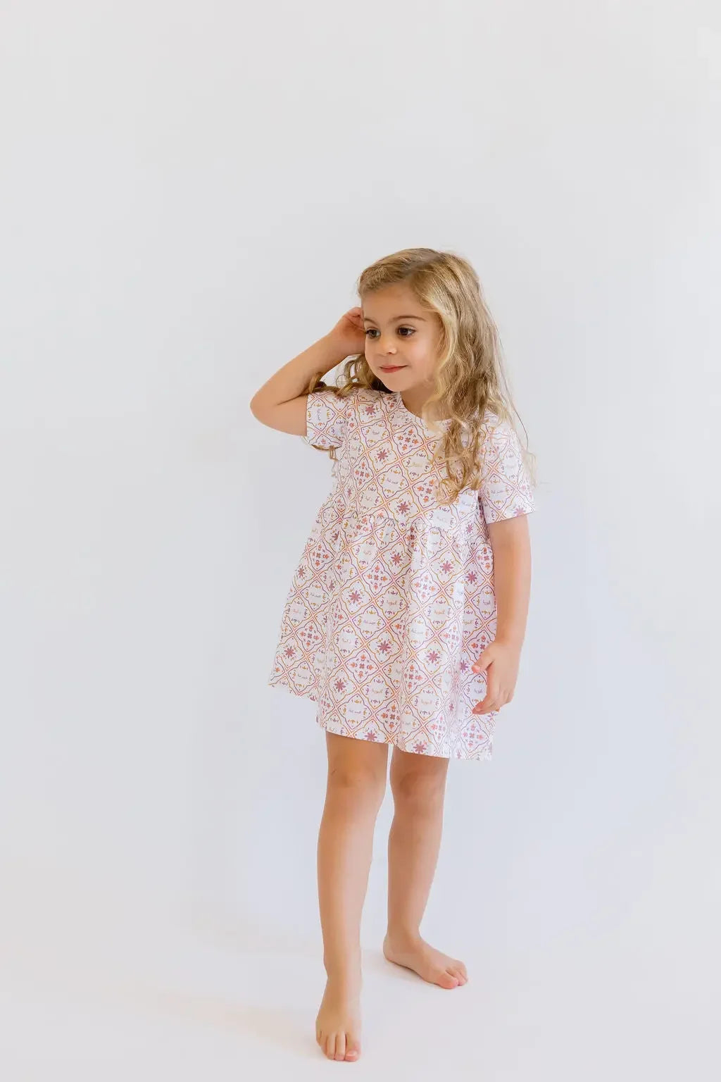 A graceful girl posing in our Arabesque Dress, featuring delicate patterns that bring timeless elegance to everyday style.