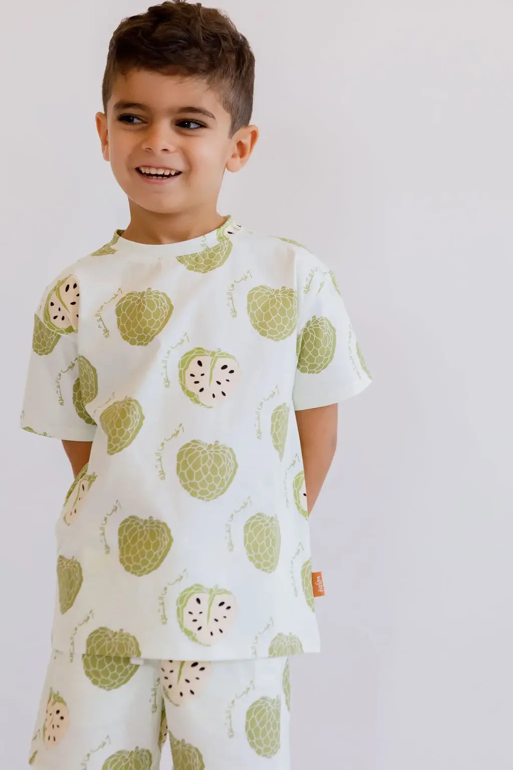 A smiling boy posing confidently in our Ashta Loungewear set, designed with playful annona fruit patterns for a fun, cozy look.
