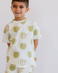 A smiling boy posing confidently in our Ashta Loungewear set, designed with playful annona fruit patterns for a fun, cozy look.