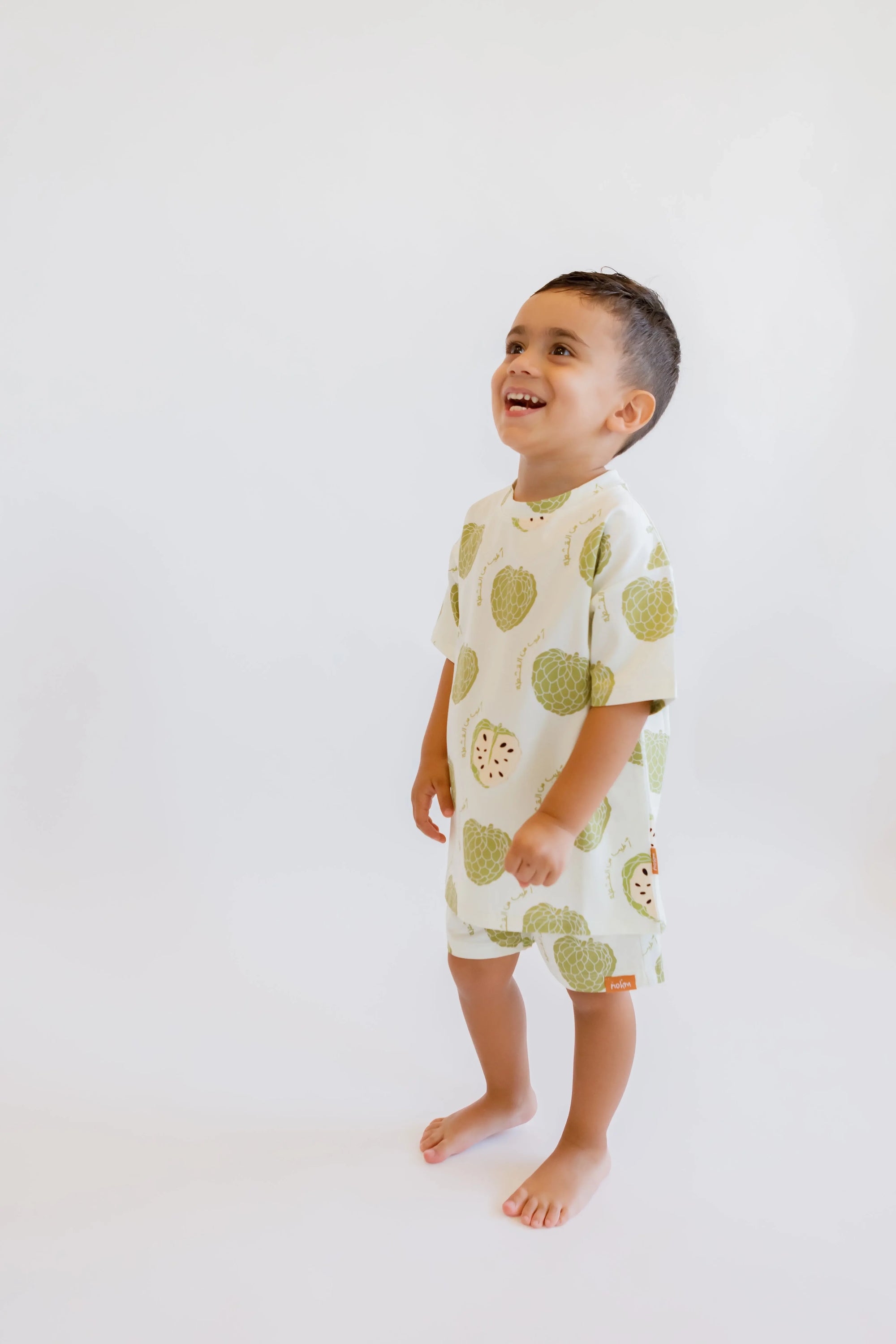 A cheerful boy laughing while wearing our Ashta Loungewear set, inspired by the playful charm of the annona fruit.