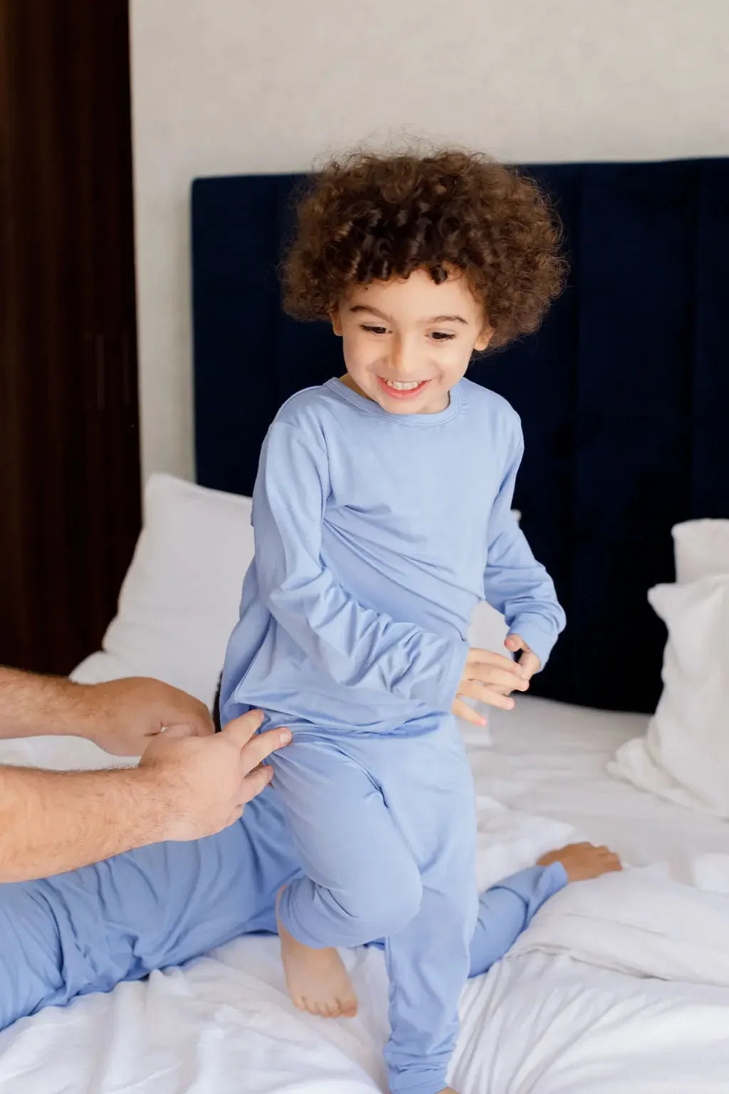 A joyful child laughing and playing on the bed in our Bahry Long Sleeve Kids Pyjama, made from ultra-soft bamboo fabric for all-day comfort.