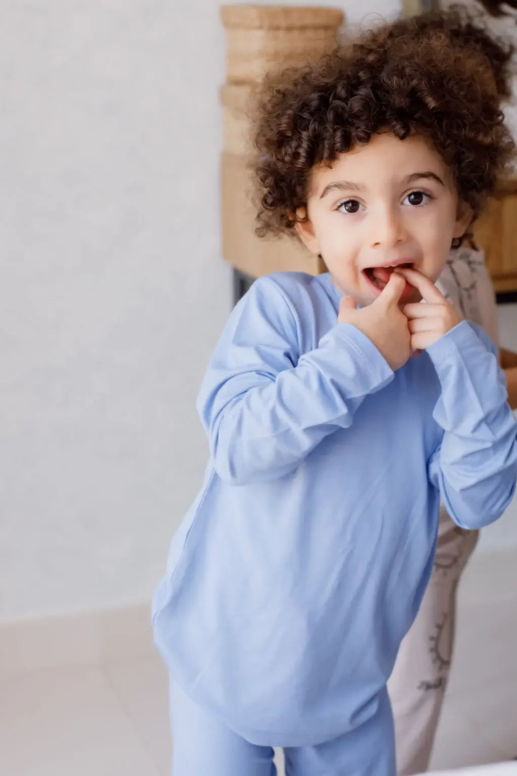 A playful child smiling shyly in our Bahry Long Sleeve Kids Pyjama, made from soft, breathable bamboo fabric for all-day coziness.