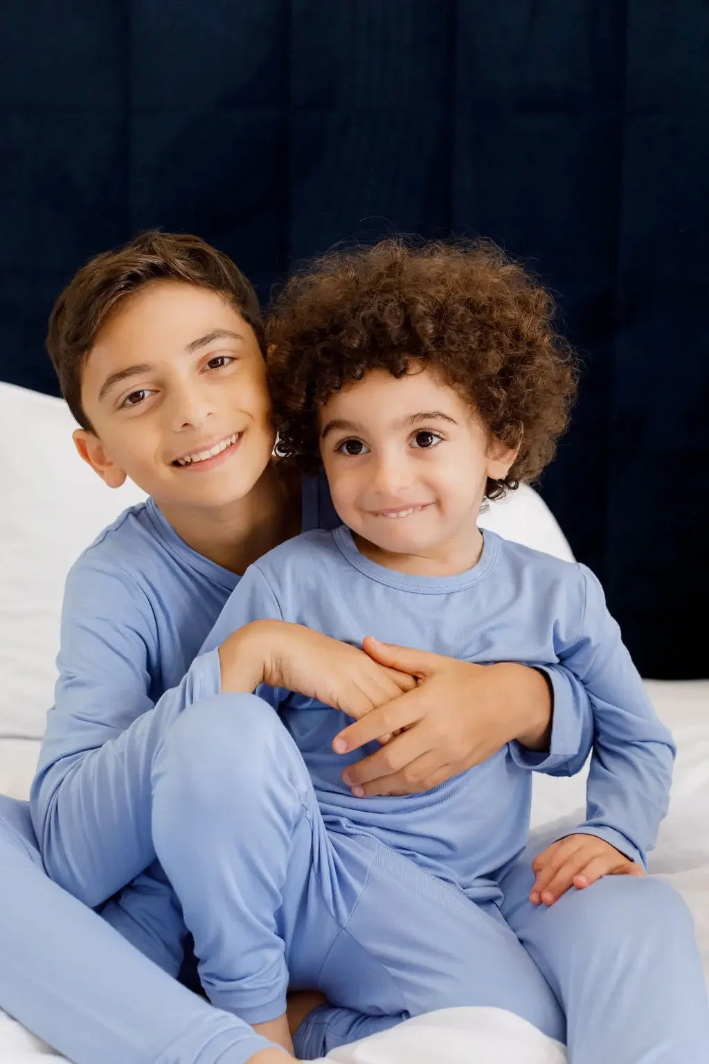 Two siblings cuddling and smiling in our Bahry Long Sleeve Kids Pyjamas, radiating warmth and comfort in soft bamboo fabric.