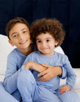 Two siblings cuddling and smiling in our Bahry Long Sleeve Kids Pyjamas, radiating warmth and comfort in soft bamboo fabric.