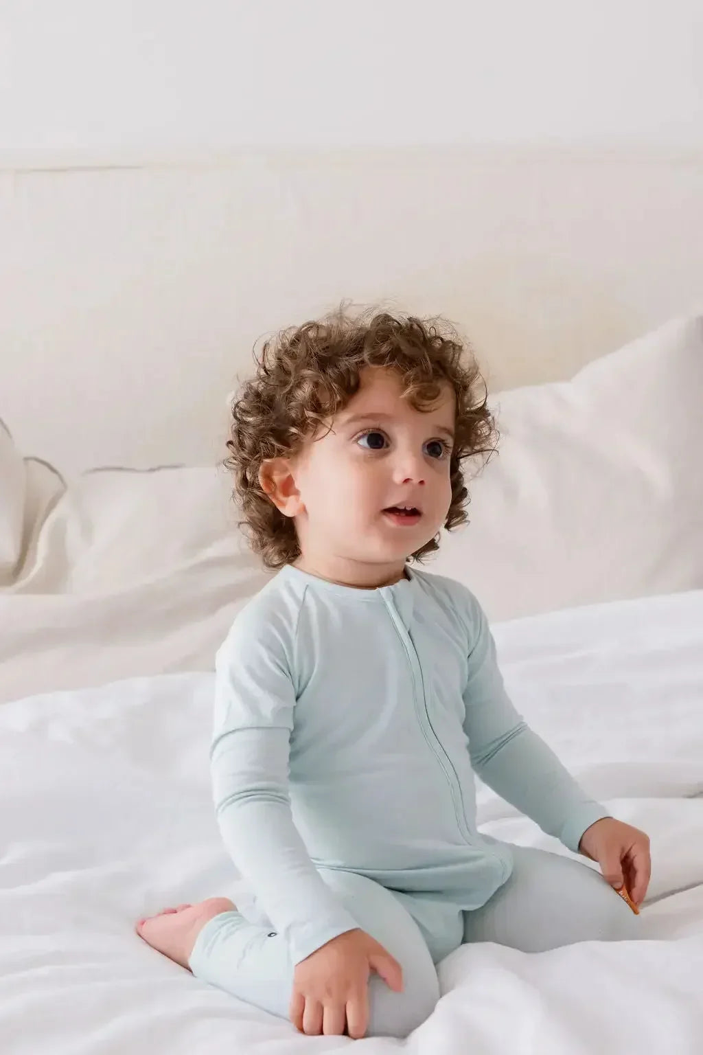 A baby wearing our Reef Pyjama, cozy in its timeless solid tone and buttery-soft bamboo fabric.