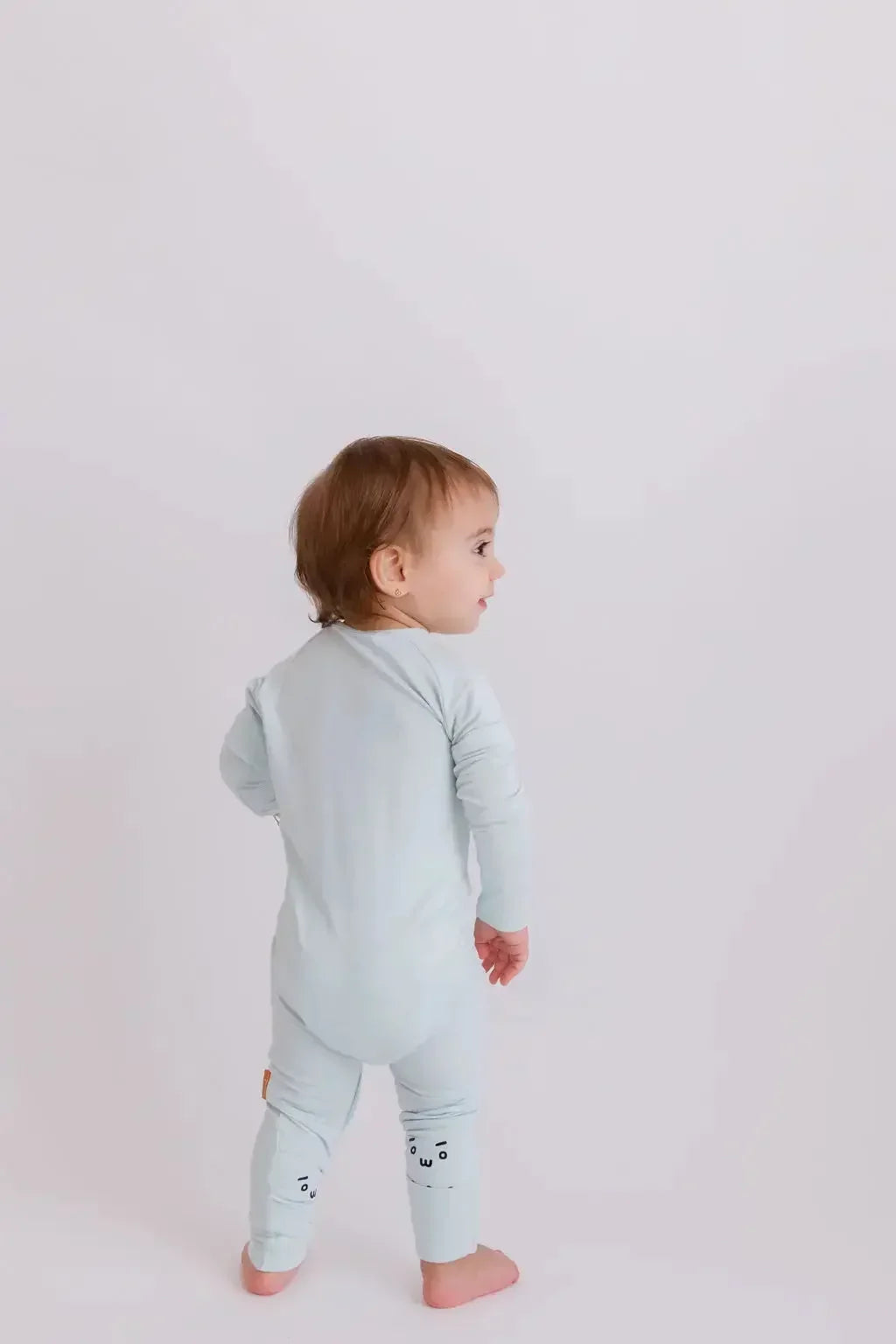 A baby wearing our Reef Pyjama, showing off its simple, gender-neutral design made for all-day comfort.