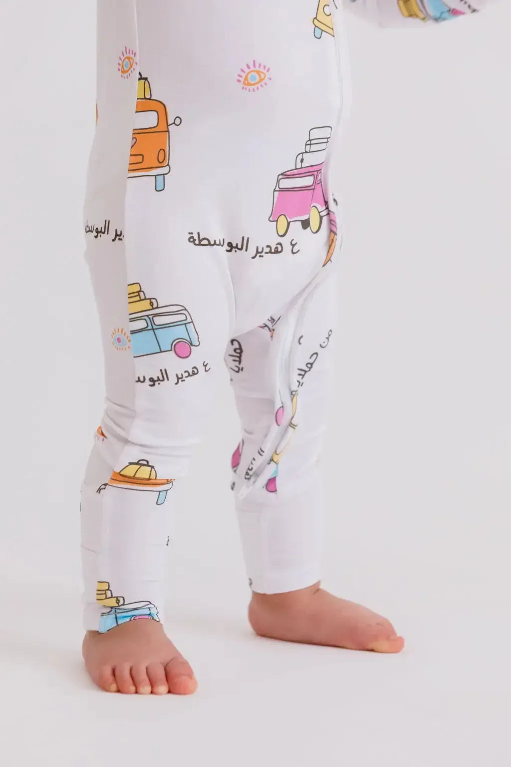 A baby wearing our Bosta Pyjama, featuring colorful Lebanese bus prints for a fun and meaningful bedtime look.