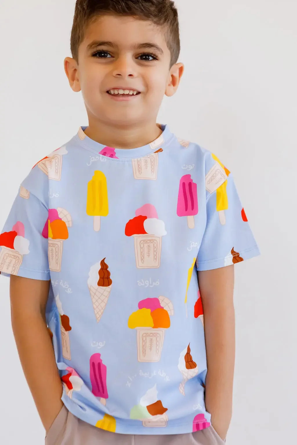 A cheerful boy smiling brightly while wearing our Boza Loungewear set, featuring colorful ice cream prints for a fun summer look.