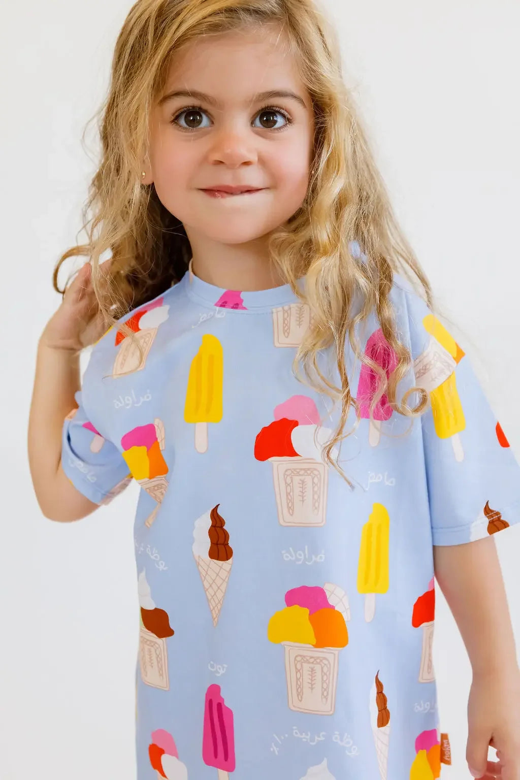 A sweet girl smiling shyly while wearing our Boza Loungewear set, covered in colorful ice cream prints that scream summer fun.