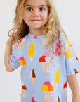 A sweet girl smiling shyly while wearing our Boza Loungewear set, covered in colorful ice cream prints that scream summer fun.