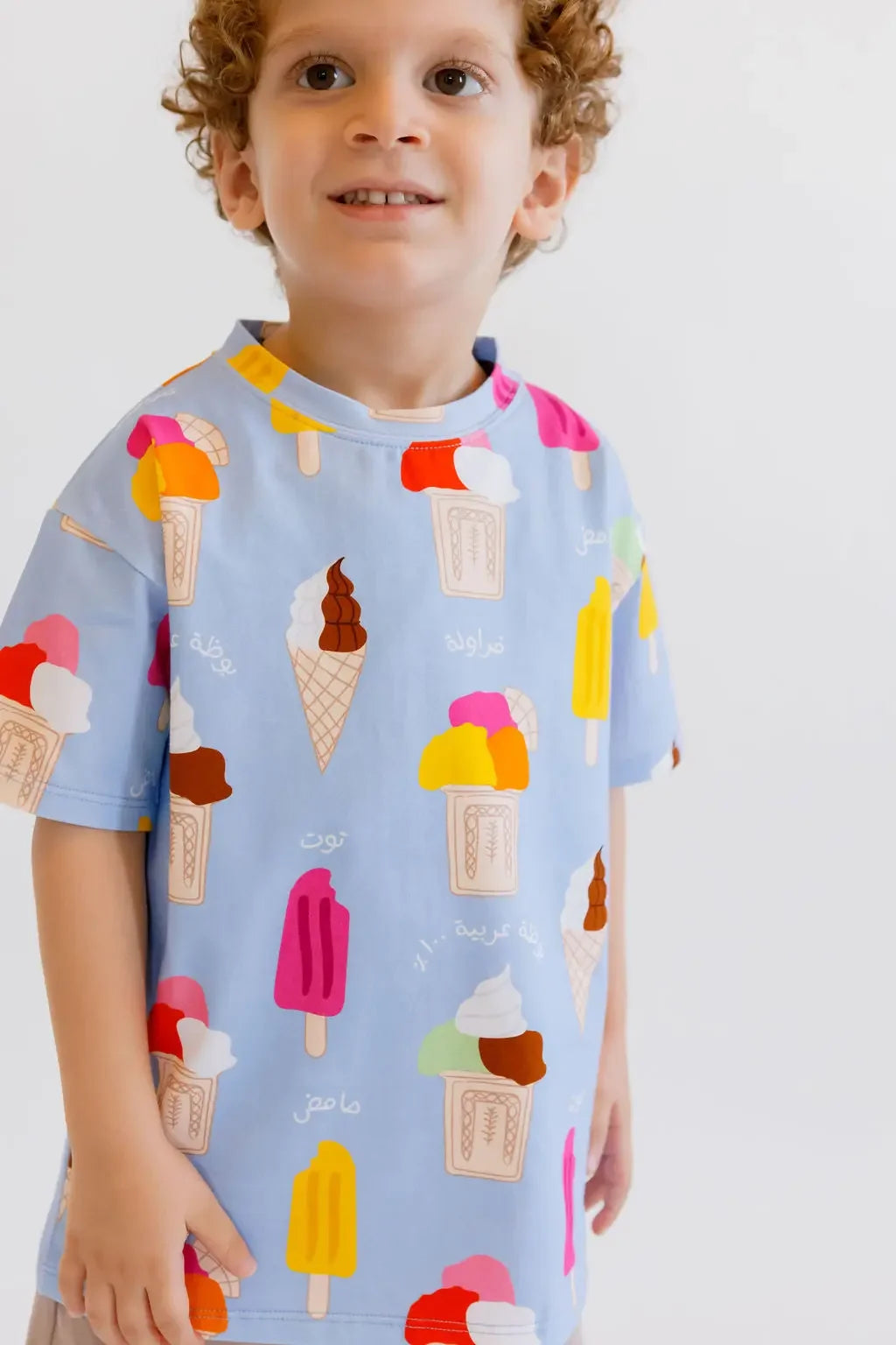 A cheerful boy wearing our Boza Loungewear set, featuring playful ice cream prints that bring summer vibes to life.