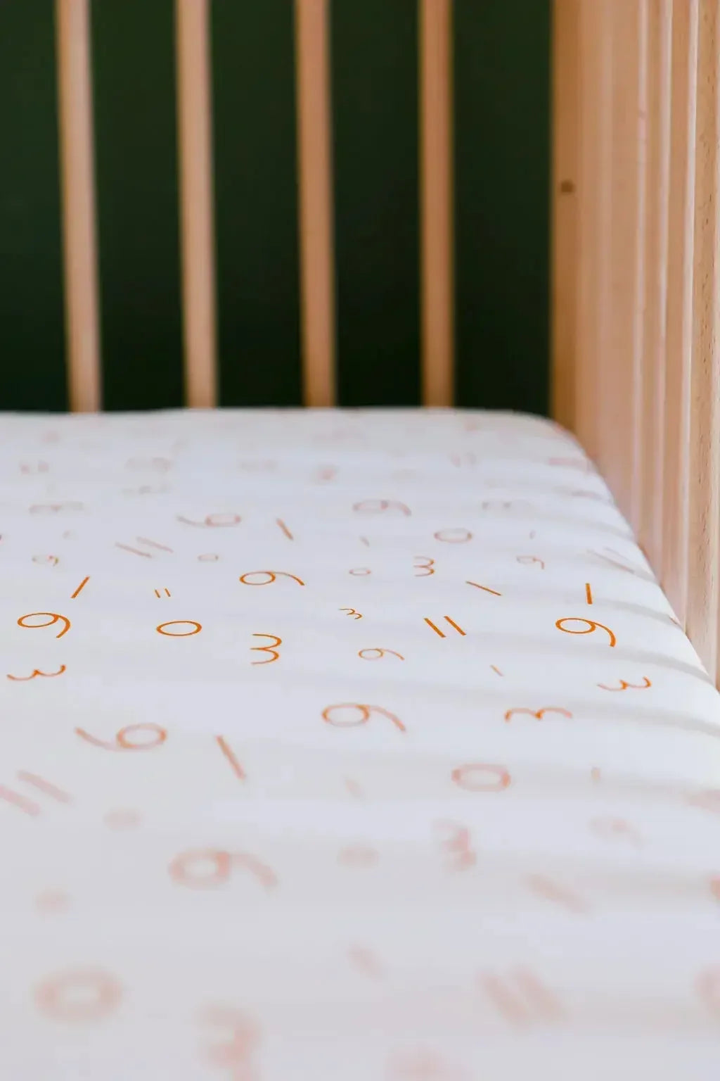 A close-up of our Nohm Harakat Crib Sheet, featuring playful Arabic-inspired patterns for a soft and cultural nursery touch.
