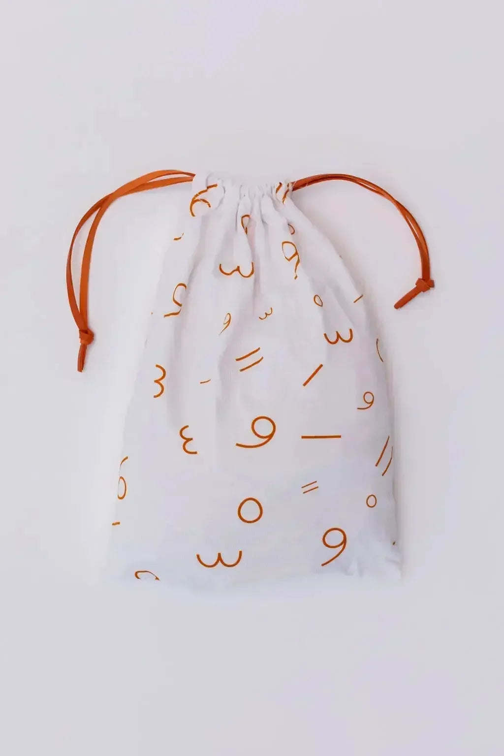 Our Nohm Harakat Bedding Set, neatly packed in its playful Arabic-patterned drawstring bag for effortless style and storage.