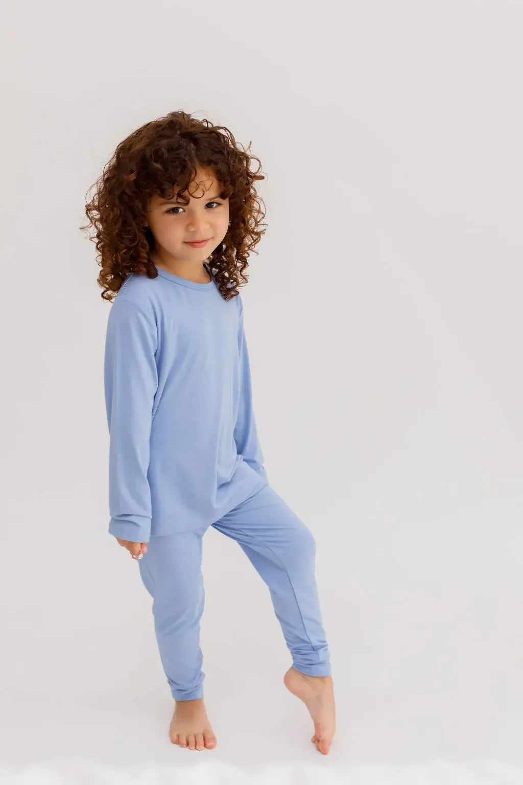 A young child wearing the **Bahry Pyjama**, a soft light-blue long-sleeve sleep set made for comfort and ease of movement.