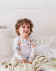A baby sitting happily on our Nohm Ramly Bedding Set, enjoying the softness and calm of its minimalist bamboo design.
