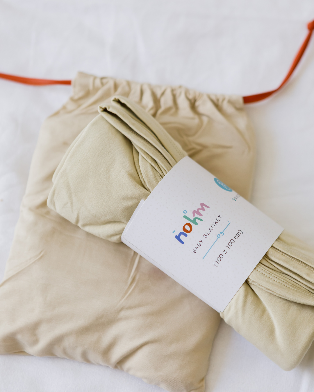 Our Nohm Ramly Bedding Set, featuring a soft beige bamboo blanket and sheet neatly packed for timeless comfort and style.