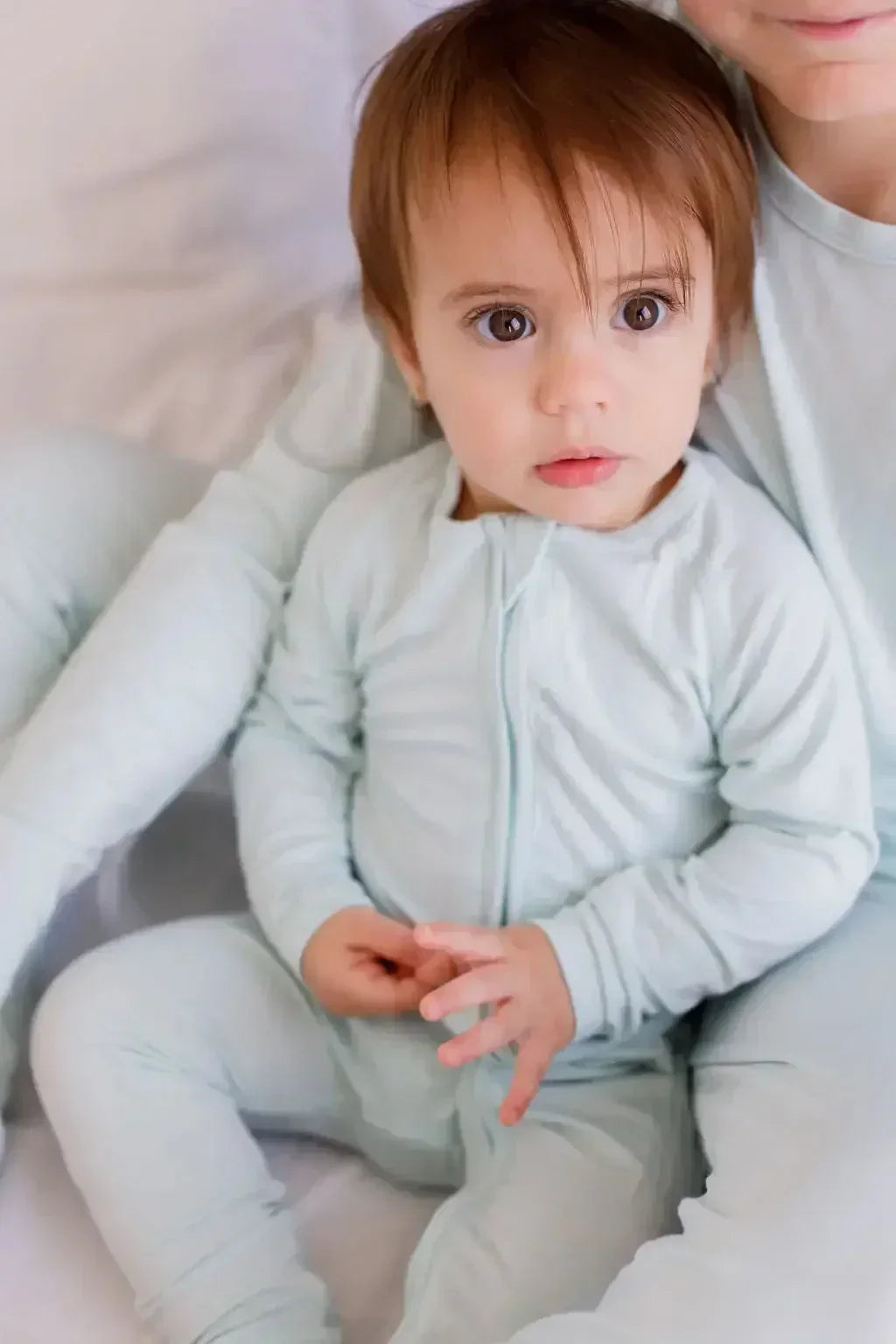A baby wearing our Reef Pyjama, cozy and calm in its soft, timeless bamboo design made for gentle snuggles.