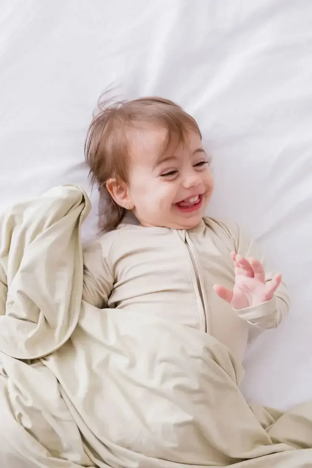 A happy baby snuggled in our Nohm Ramly Bedding Set, wrapped in the pure comfort of soft, breathable bamboo fabric.