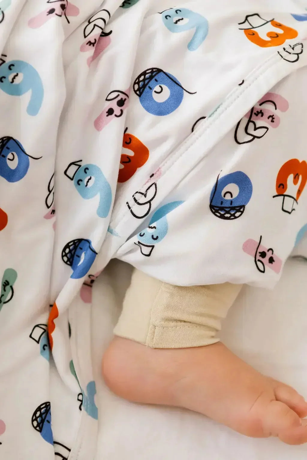 A cozy close-up of our Nohm Tanween Bedding Set, showing its soft bamboo fabric and charming Arabic-inspired prints.