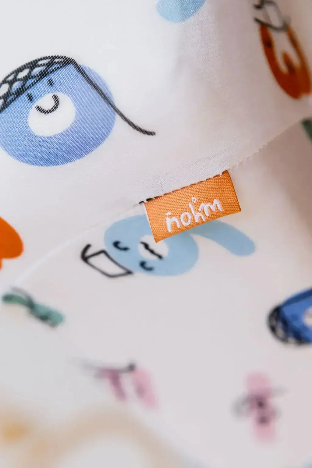 
A detailed close-up of our Nohm Tanween Bedding Set, highlighting the playful Arabic-inspired design and signature Nohm tag.