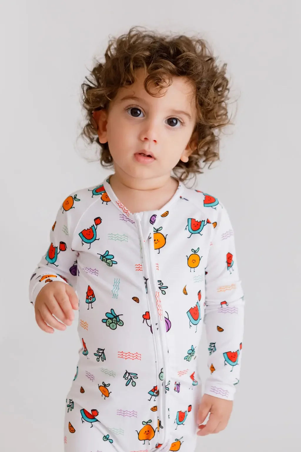 A toddler wearing the **Watermelon Pyjama** from the **Watermelon Bundle**, featuring a white base with bright watermelon-inspired fruit prints for a fun and cheerful look.
